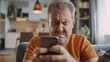 Middle aged male staring at smartphone screen with angry face expression