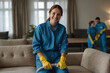 Dry cleaning of upholstered furniture.An employee in a special jumpsuit cleans the sofa.