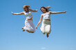 Happy girls jumping against the sky
