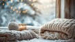 A candle and a blanket on the window sill in front of snow, AI