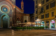 Old square with restaurant tables in front of the church Santa Maria del Carmine in Milan, Italy. Night cityscape of Milan. Architecture and landmarks of Milan.