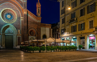 Poster - Old square with restaurant tables in front of the church Santa Maria del Carmine in Milan, Italy. Night cityscape of Milan. Architecture and landmarks of Milan.