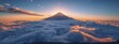 The isolated mountain peak stands majestically above a blanket of clouds as the sun begins to rise.