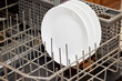 Close up of a white ceramic bowl in the lower rack of a dishwasher