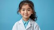 Full length portrait of smiling Asian child aspiring to be future doctor writing prescription in clipboard in blue isolated background