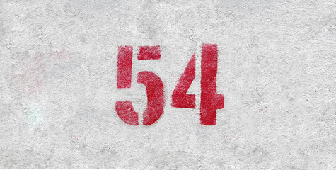 Red Number 54 on the white wall. Spray paint.