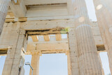 Fototapeta Desenie - Sunlight flares over ancient Greek architectural ruins with sky in the background, in Athens Greece