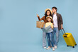 © Home-stock - Family travel. Excited parents with daughter, man carrying suitcase and girl holding map, mother pointing aside at copy space on blue background