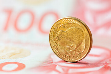 Wall Mural - New Zealand dollar, Financial concept, 1 dollar coin with kiwi on the background of 100 dollar banknotes