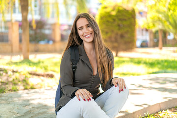 Wall Mural - Young woman at outdoors with happy expression