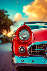 Canvas Print - Red car with silver grill has one headlight showing brightly while the other is off.