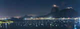 Fototapeta Las - Panoramic Night View of Sailboats and City Lights by the Sea