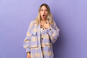 Poster - Young blonde woman isolated on purple background surprised and shocked while looking right