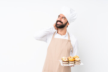 Wall Mural - Young man holding muffin cake over isolated white background thinking an idea
