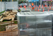 Bricks wrapped in plastic on a construction site. Unrecognizable worker keeping the traffic moving. Auckland.
