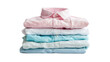 
An image of a stack of perfectly folded clothing items. Macro shot of a pile of shirts, sweaters and pants in various pastel colors.