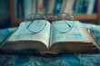 An open book lies flat. Perched atop the book are a pair of glasses