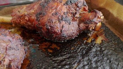 Two roasted mutton lamb leg covered with baking paper on baking tray