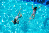 Fototapeta Miasto - kids swimming in pool underwater.