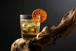 Old fashioned cocktail with ice and dried orange slice on a old snag.