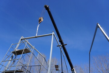 Installation of metal structures using a crane
  against the blue sky