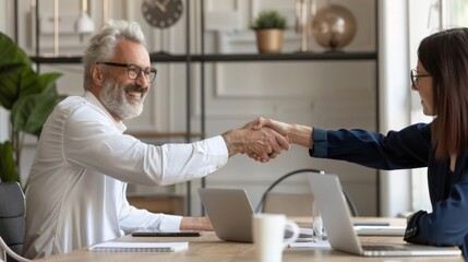Aufkleber - A man shakes hands with a woman in a business setting