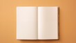 An open hardcover book with blank pages on a tan background