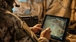 © Maksym - In a tactical command post, military personnel study mission updates on a tablet next to a deployed Starlink antenna, demonstrating real-time data access and communication capabili
