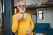 © Miljan Živković - One senior man stand in at door of tiny house happy smile hold cup