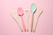 Different spatulas on pink background, flat lay