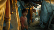 A small lonely Asian boy stands at his tent in a refugee camp. There is fear and hopelessness in his eyes
