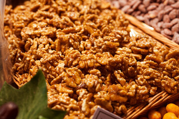 Wall Mural - Sweet walnut kernels in caramel glaze on counter in market