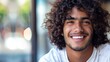 Portrait of handsome man with curly hair smiling and looking at camera