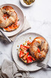 Breakfast variety of bagels with salmon and strawberries, white marble background.