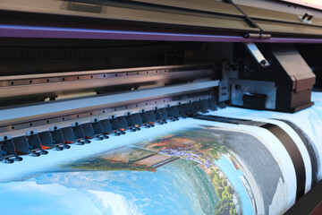 Poster - A printer is printing a picture,  printer is black and silver. The image is blurry