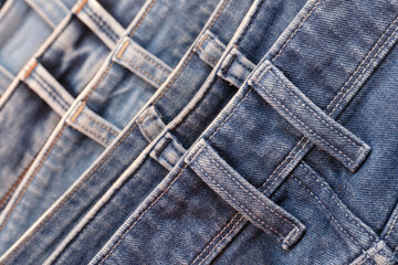 Aufkleber - A row of jeans with different colors and patterns. The jeans are hanging on a rack