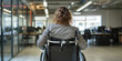 Rear view of businesswoman with disability uses wheelchair while going through the office