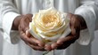   Person holding flower against white background ..Or, if you prefer:..Up-close view of person holding flower before white backdrop