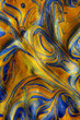 Closeup of golden and blue fluid metallic acrylic paint textured background