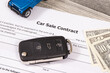 Form of car sale agreement, dollar baknotes, blue toy car and key. Sales and purchases new or used vehicle
