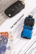 Car sale contract, euro banknotes, blue toy car and black key. Sales, purchases of vehicle