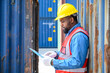 African American logistic workers wear yellow helmets and reflection shirts, hold document paper and look to check inventory or job details at the shipping container yard.