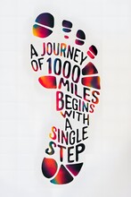 An Inspiring Word Art Design That Captures The Essence Of Embarking On A Journey. The Phrase "a Journey Of 1000 Miles Begins With A Single Step" Is Intricately Formed Into The Shape Of A Foot Print