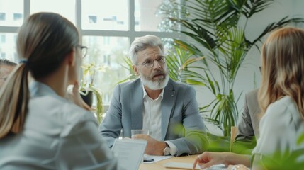 Poster - A man in a suit is sitting at a table with three other people