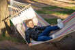 Summer active leisure for kids. Child swinging and relaxing in hammock.
