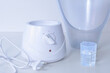 Facial steamer - white devices with water containers on a table. Close up