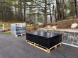 Pallets of solar panels in driveway delivered to home for rooftop installation