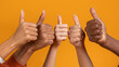 © Prostock-studio - Diverse hands giving thumbs up sign on orange background