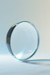 A glass lens with a beveled edge sits on a reflective surface.