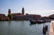 Panoramic view of bell tower of Chieso di San Pietro Martire next to water channel on Murano island in city of Venice, Veneto, Italy, Europe. Venetian architectural landmarks and wooden timber piles
